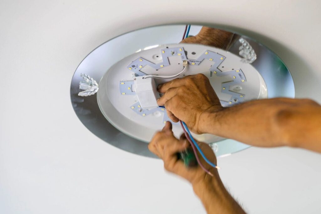 Electrician installing a recessed LED light fixture